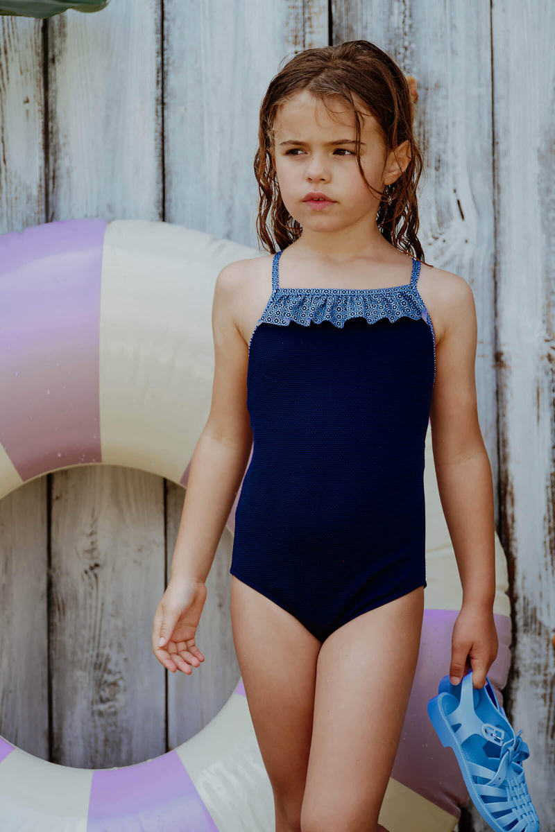 Girl wearing a Navy Azulejos one piece swimsuit